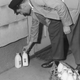 Milkman leans down to deliver milk